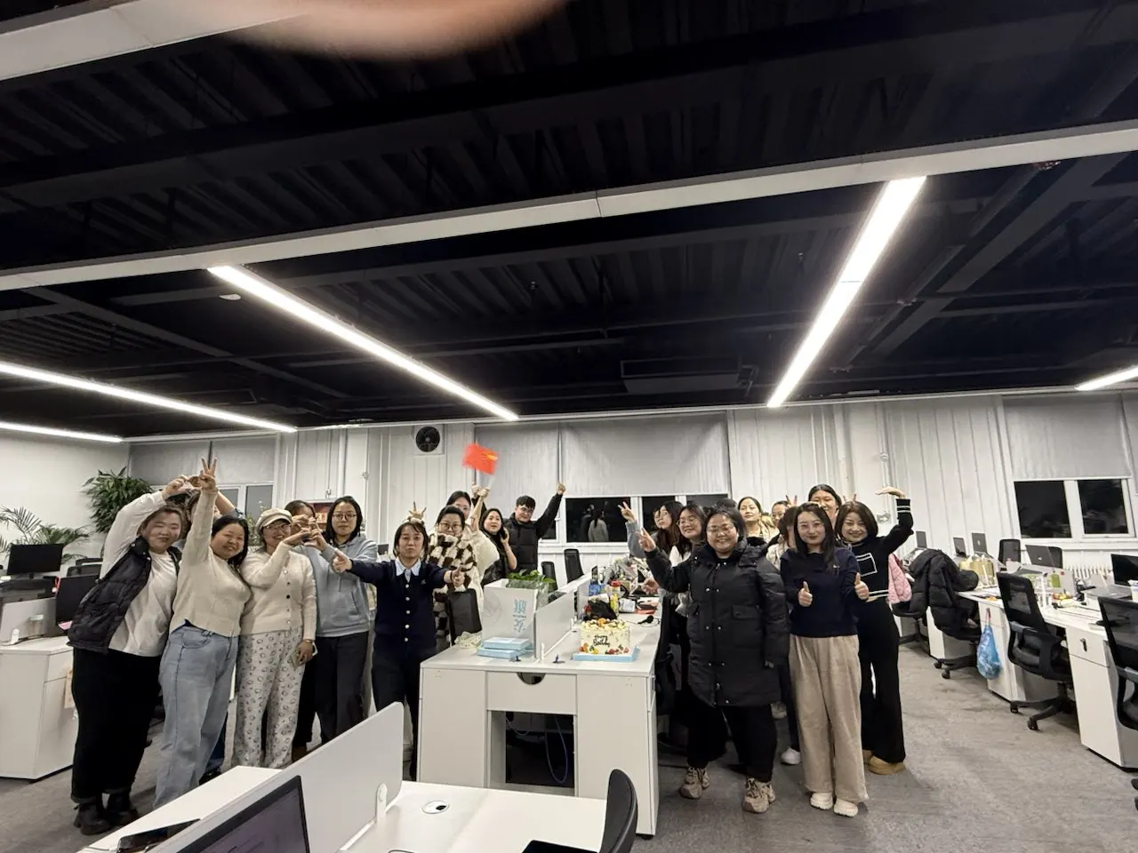 Tengxuan employees posing together in an office at night