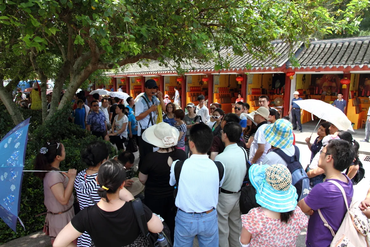 Tour guide addressing a group of travelers in China