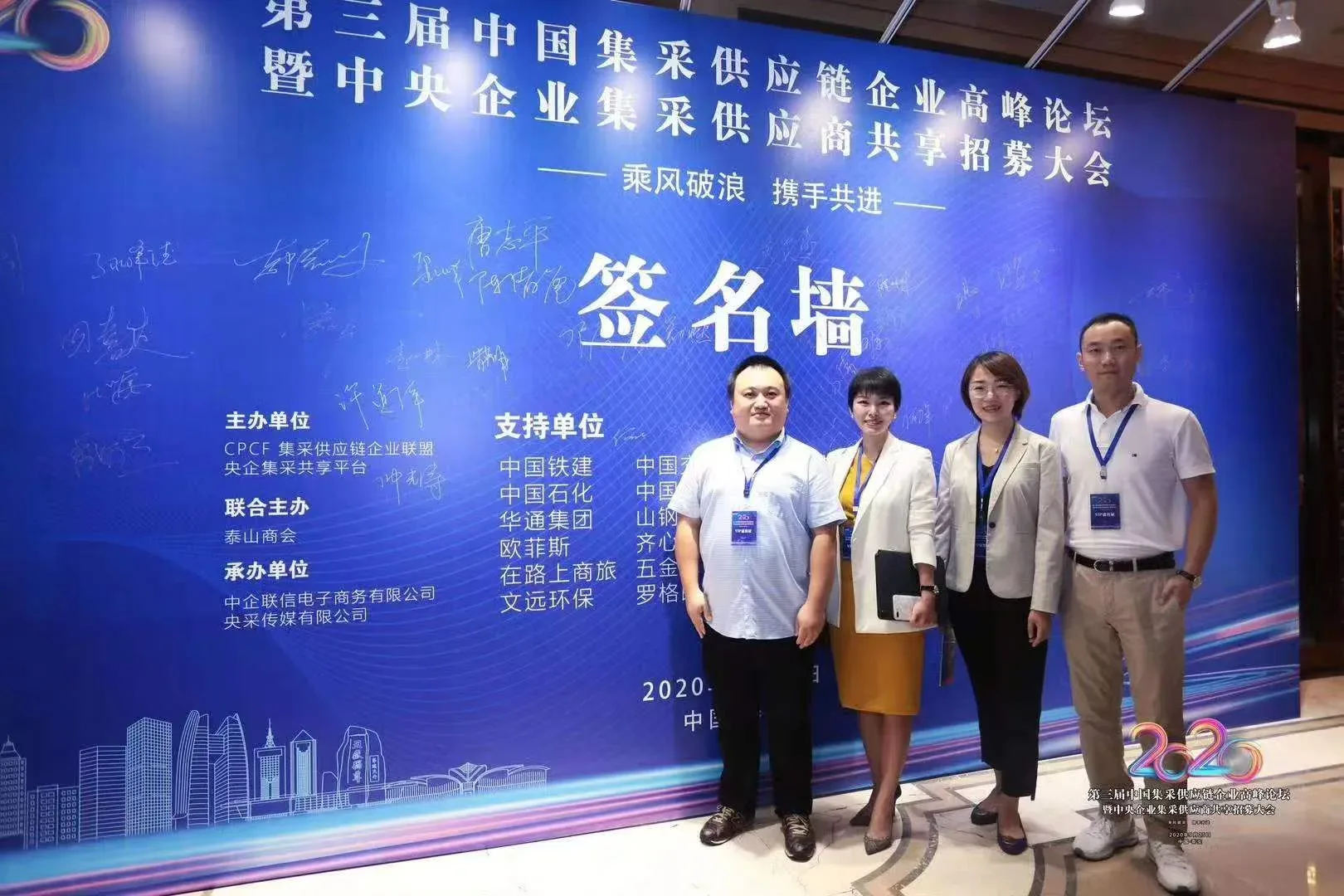 Tengxuan Travel team members standing at an industry forum signing wall