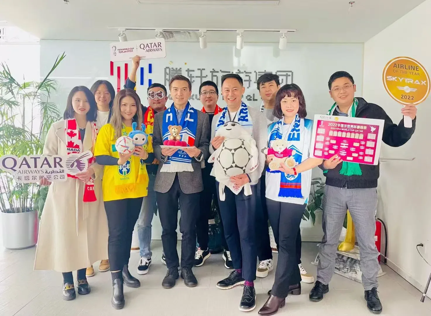 Tengxuan Travel team posing with Qatar Airways themed props